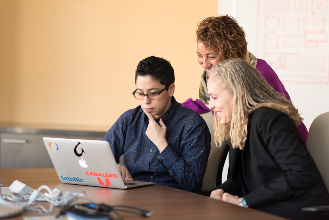 three-women-beside-table-looking-at-macbook-ndovgcs-lzm